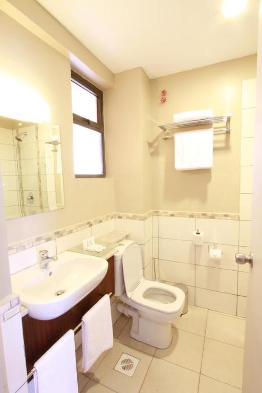 a bathroom with a white toilet and a sink at Hotel Rio in Nairobi