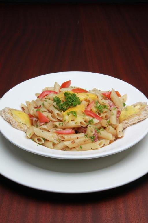 a plate of pasta with vegetables on a table at Hotel Rio in Nairobi