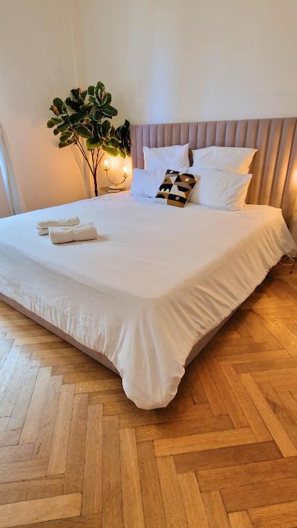 Elle comprend un grand lit avec des draps et des oreillers blancs. dans l'établissement Jazzy et Spacieux Appartement Prom des Anglais, à Nice