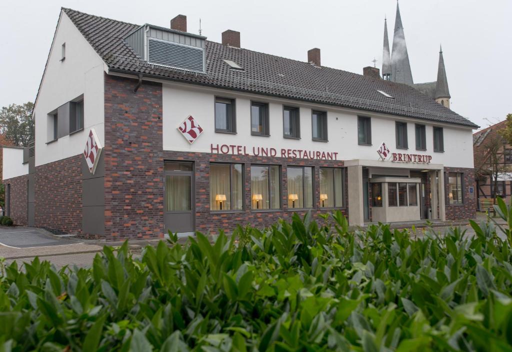 un patio de hotel con arbustos frente a un edificio en Hotel Restaurant Brintrup, en Münster