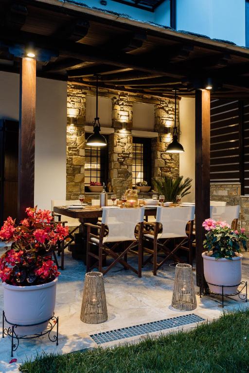 a patio with tables and chairs and some flowers at Melithos Villa in Koropi