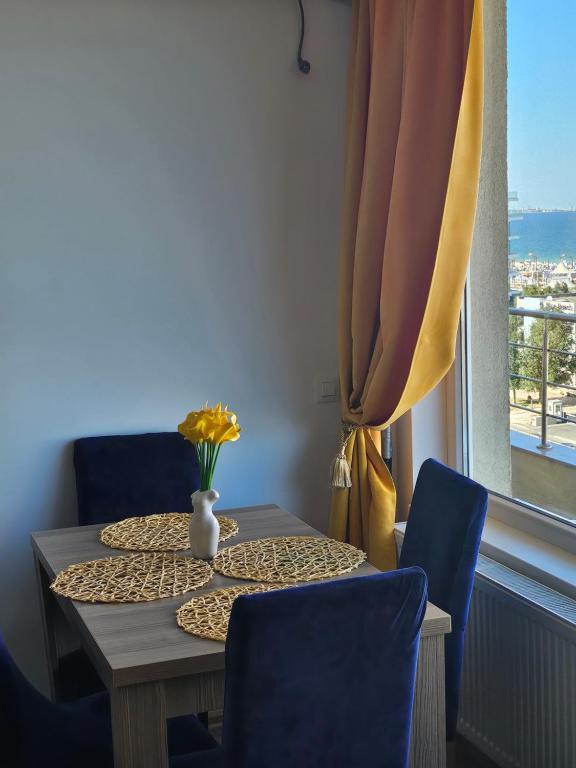 un tavolo con due sedie e un vaso con dei fiori sopra di Mamaia a Mamaia