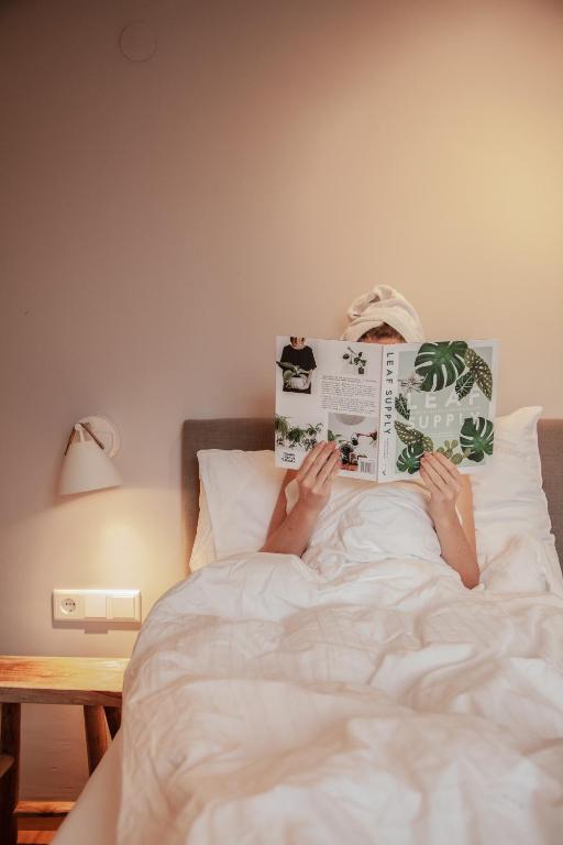 a person laying in bed reading a book at VOM REITER, Ferienwohnung am Bauernhof mit Bergblick und privater Infrarotkabine, Inklusive Sommercard in Schladming