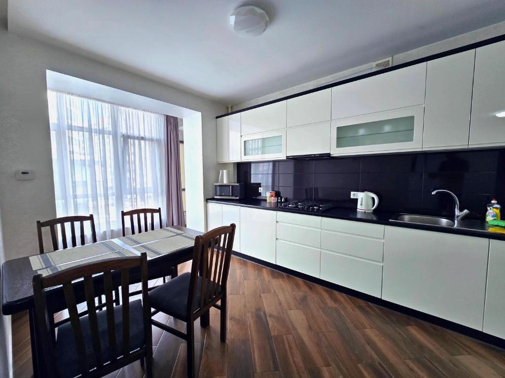 a kitchen with a table and a dining room at Apartment on Belvedere in Ivano-Frankivsʼk