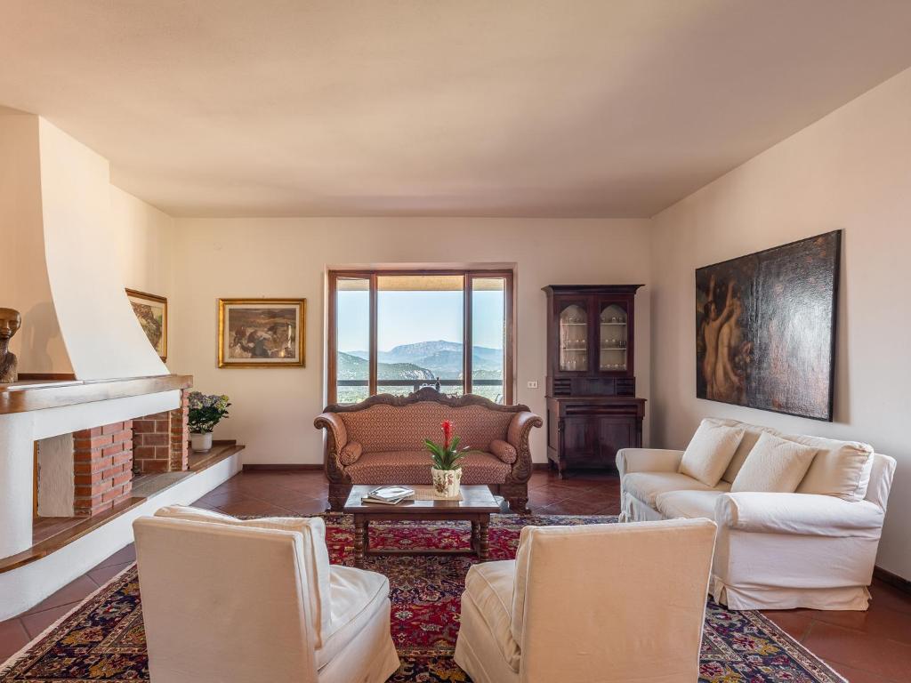 a living room with two couches and a fireplace at Villa Billia Sardinia Domus in Dorgali