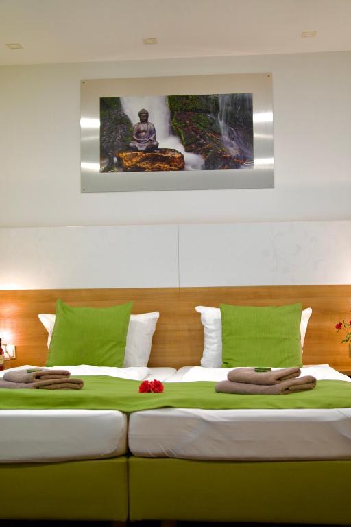 a bedroom with a large bed with green and white sheets at B&B Outlet Hotel - Metzingen - Bad Urach - Free Parking in Dettingen an der Erms