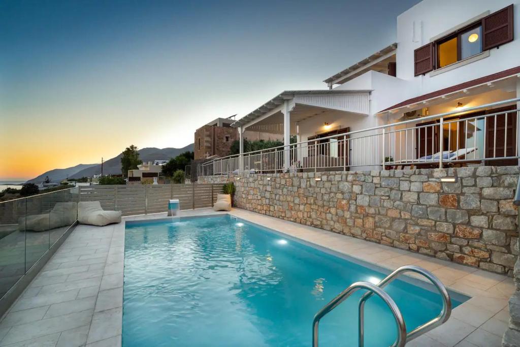 a swimming pool in front of a house at Villa Alia in Sfakiá