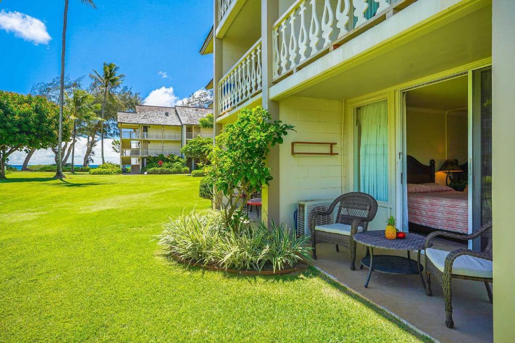 a porch of a house with a table and chairs at Islander on the Beach 115 in Kapaa