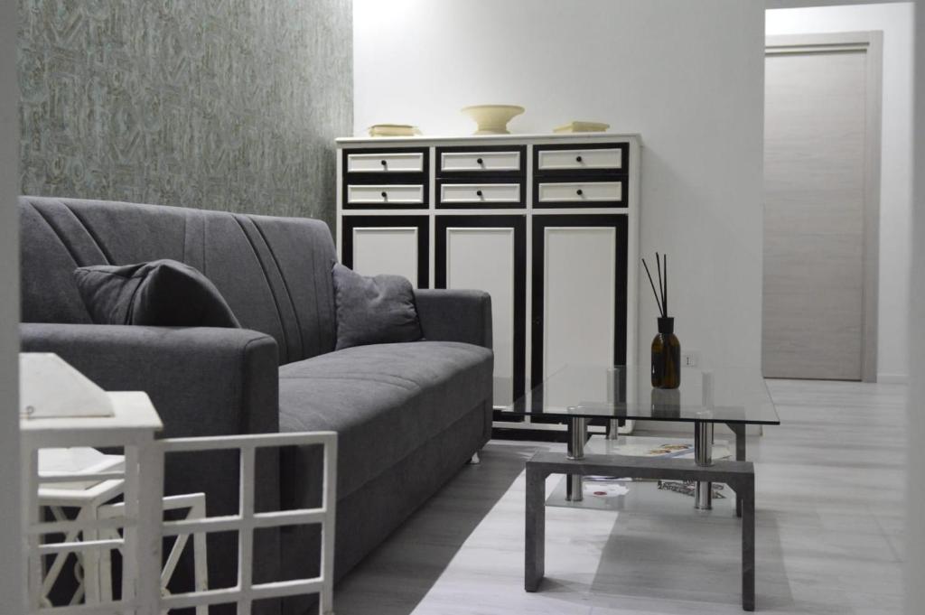 un soggiorno con un divano e un tavolo di Adriano's Rooms a Catania