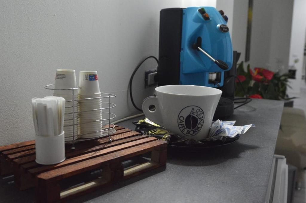 un tavolo con una tazza di caffè e una macchinetta del caffè di Adriano's Rooms a Catania