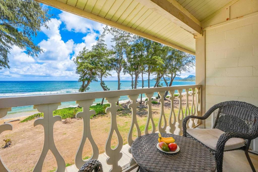 een tafel en stoelen op een veranda met uitzicht op de oceaan bij Islander on the Beach 323 in Kapaa