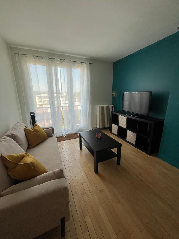 un salon avec un canapé et une télévision dans l'établissement Superbe apart proche transports, à Rueil-Malmaison