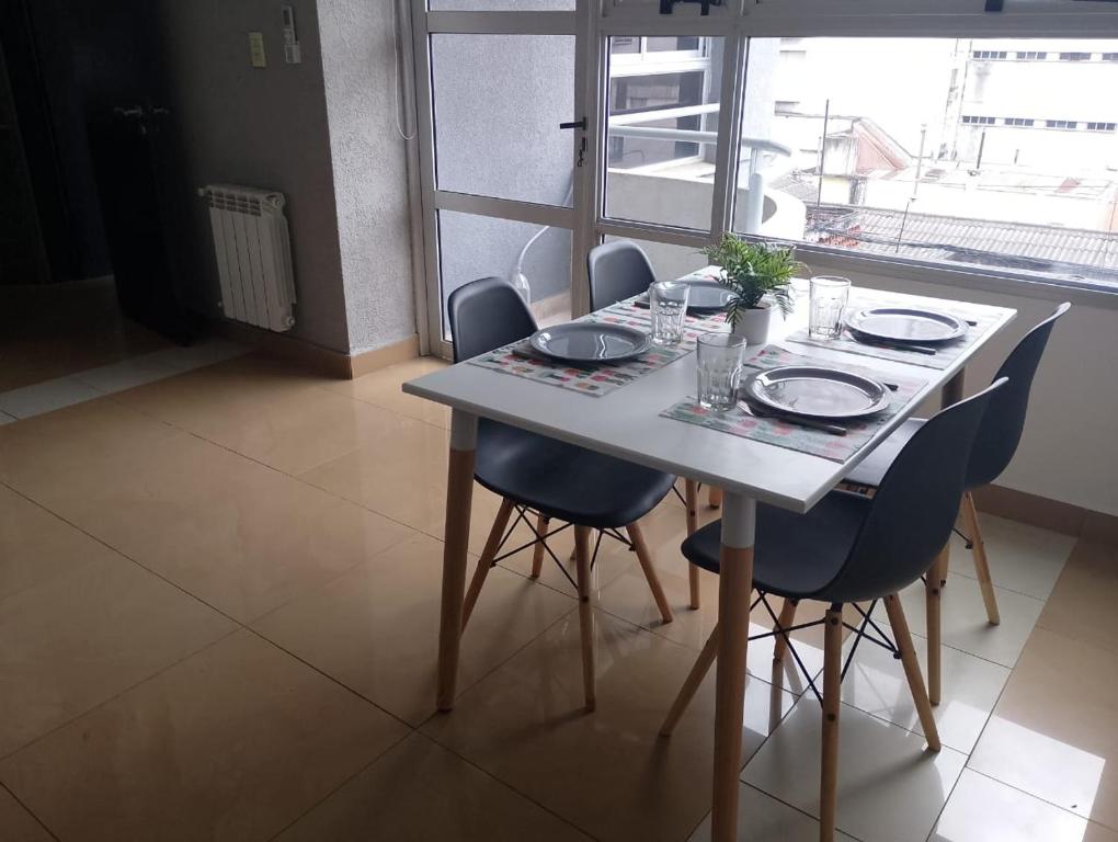a table with chairs and plates and glasses on it at Dpto vista al cerro in Salta