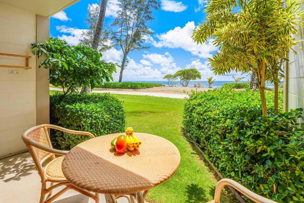 a table with fruit on it on a patio at Islander on the Beach 152 in Kapaa