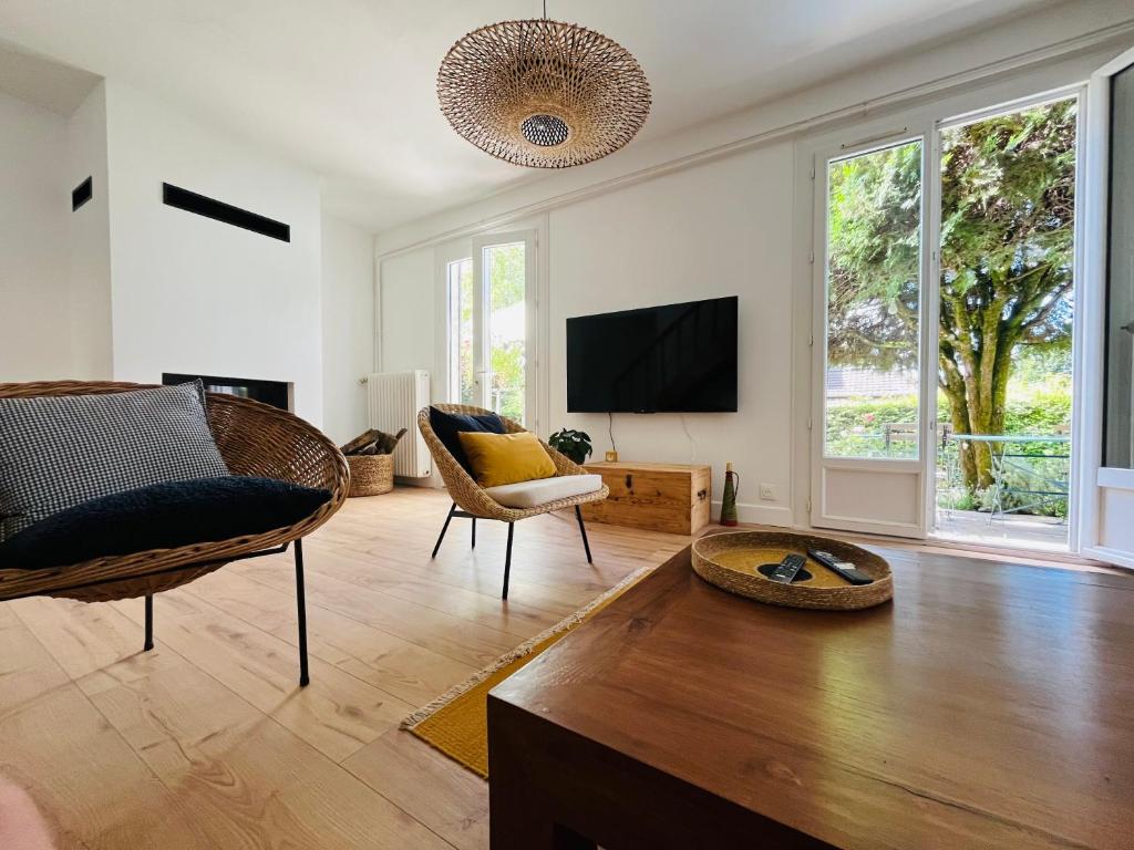 a living room with a tv and a couch and chairs at Chez Gilles et Aline in Figeac