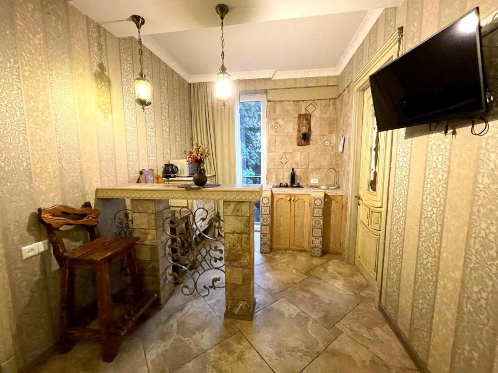 a kitchen with a counter and a tv on the wall at Loka Chovelidze in Tbilisi City