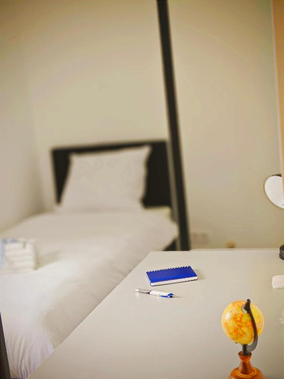 ein Tisch mit einem Buch und einem Stift auf einem Bett in der Unterkunft Jakz Hotel in Herten