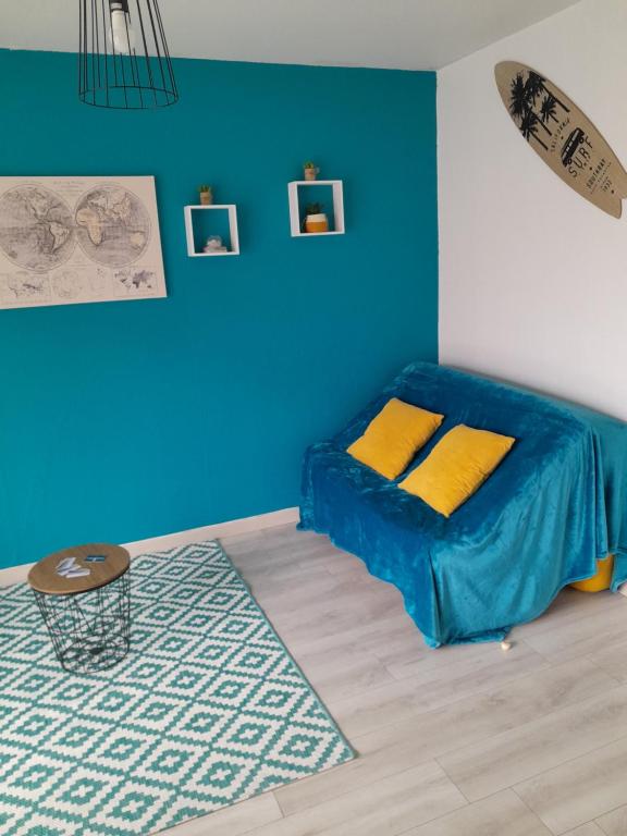 une chambre avec un lit avec un mur bleu dans l'établissement Costa Del Calès, à Calais