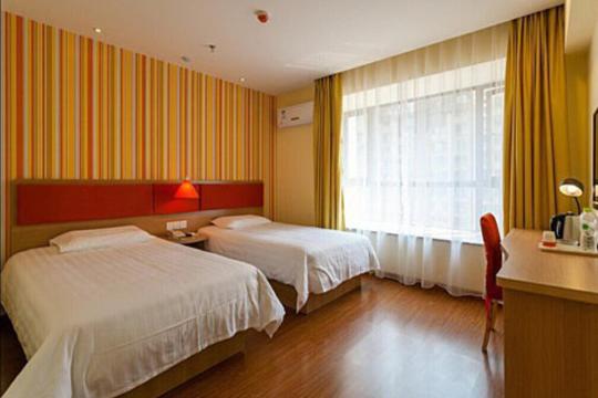 um quarto de hotel com duas camas e uma janela em Home Inn Shanghai Nicheng Lingang Facility Industrial Park em Nanhui