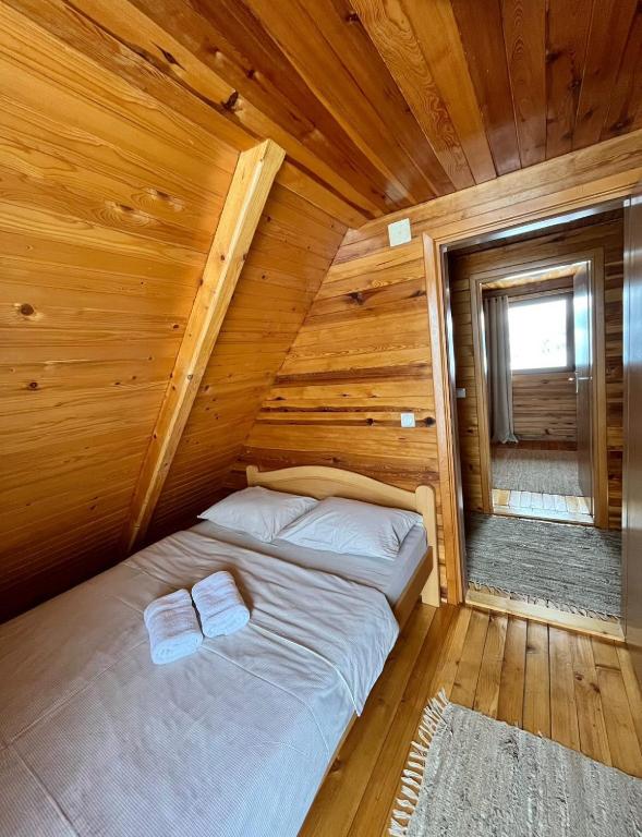 a bed in a cabin with wooden walls at Brvnare Sekulic in Sekulić 
