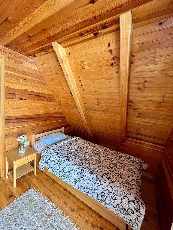 a bedroom with a bed in a log cabin at Brvnare Sekulic in Sekulić 