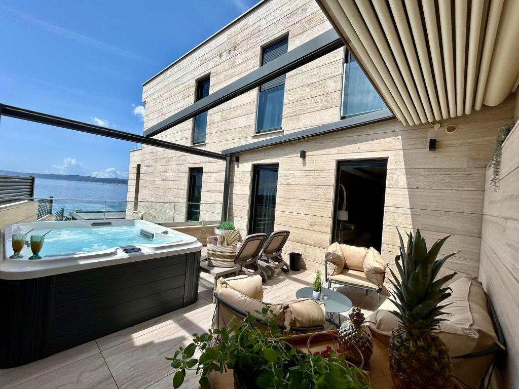 a patio with a jacuzzi tub in a house at BEACH FRONT VILLA FRAN - DELUXE SEA VIEW SUITE with private jacuzzi # 3 in Crikvenica