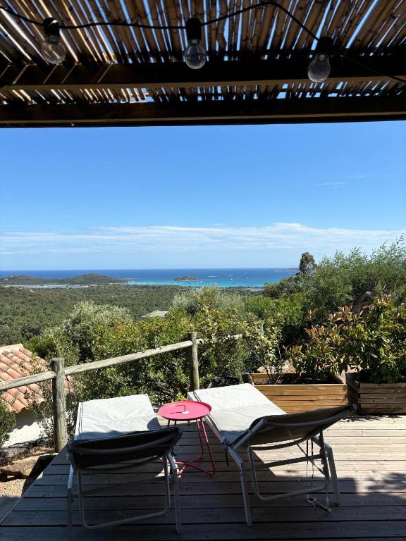 - deux chaises et une table sur une terrasse donnant sur l'océan dans l'établissement CASA ANPÀ - Appartement Vue Mer, à Zonza