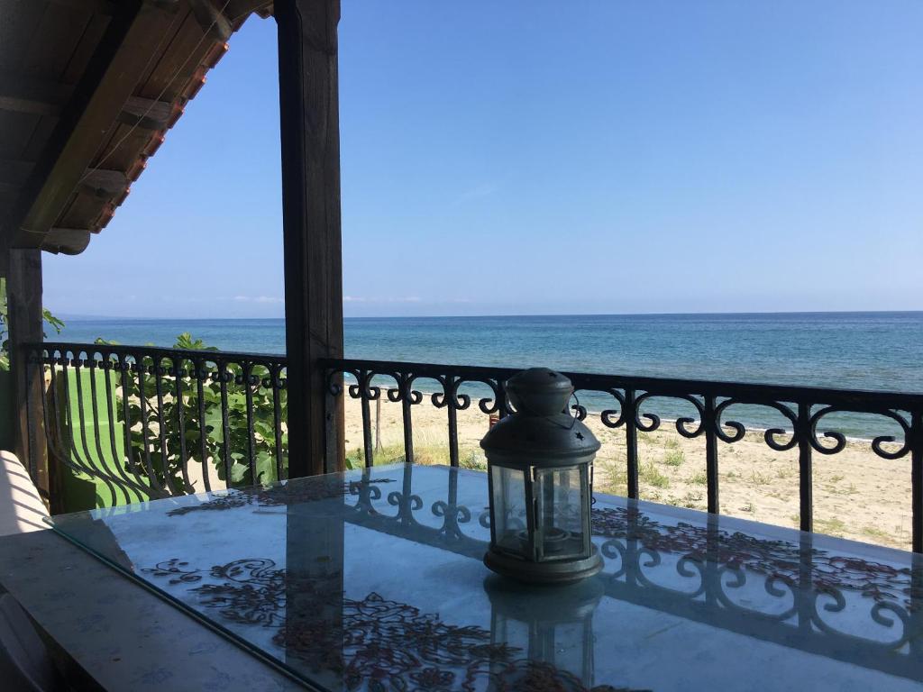 a lantern sitting on a table on a balcony overlooking the beach at Ανατολή apartment in Néa Meságkala