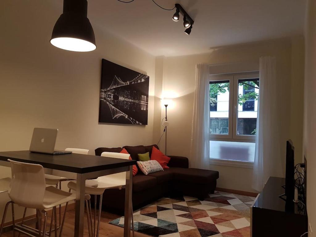 ein Wohnzimmer mit einem Sofa und einem Tisch mit einem Laptop in der Unterkunft Donosti House con Parking ESS in San Sebastián
