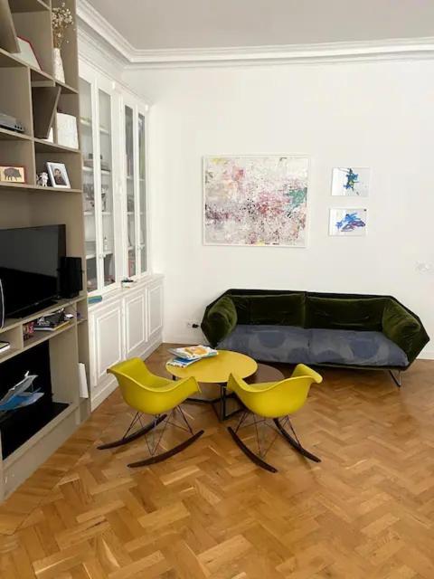 - un salon avec une table et deux chaises jaunes dans l'établissement Stunning family Flat at the very heart of Paris, à Paris