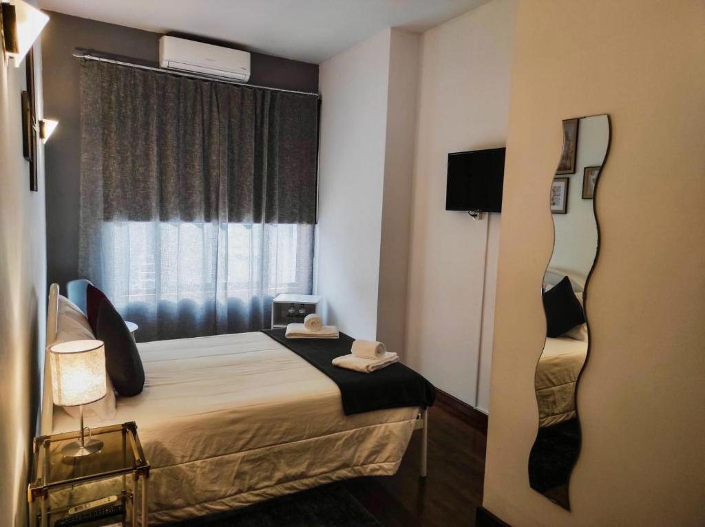 um quarto de hotel com uma cama e uma janela em Alojamento Local Tamega em Amarante