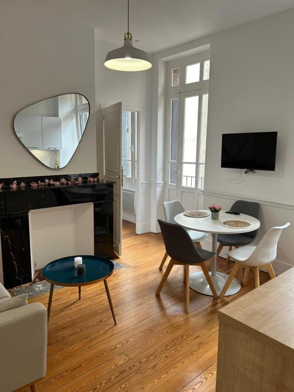 - un salon avec une table, des chaises et un miroir dans l'établissement Le Toulousain 201 - Appartement Cosy en Hypercentre - Quartier Jeanne d'Arc, à Toulouse