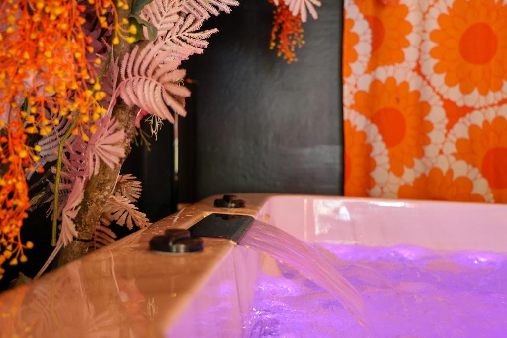 La salle de bains est pourvue d'une baignoire et d'un vase fleuri. dans l'établissement Divas 1970, à Marolles