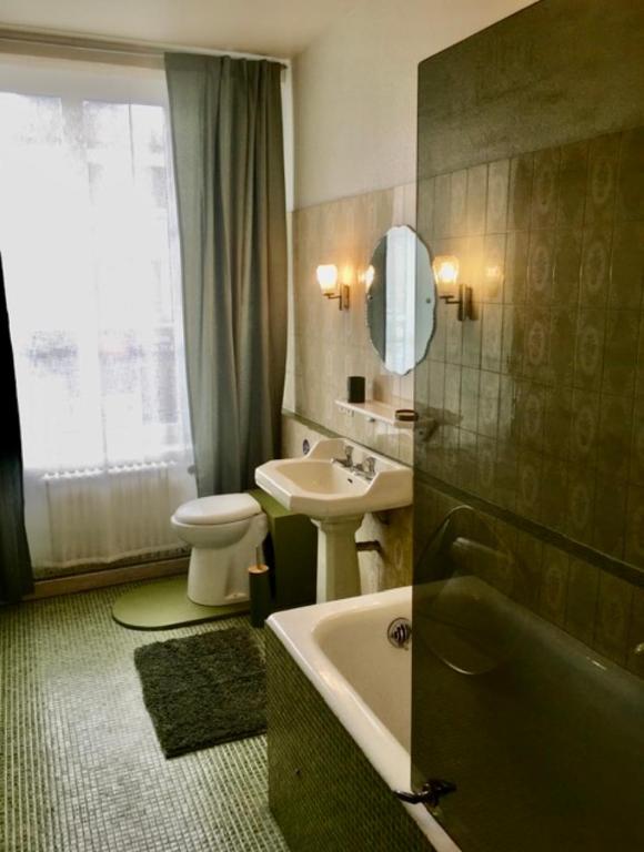 une salle de bain avec un lavabo, une baignoire et des toilettes dans l'établissement La Marie-Thérése, à Auxi-le-Château