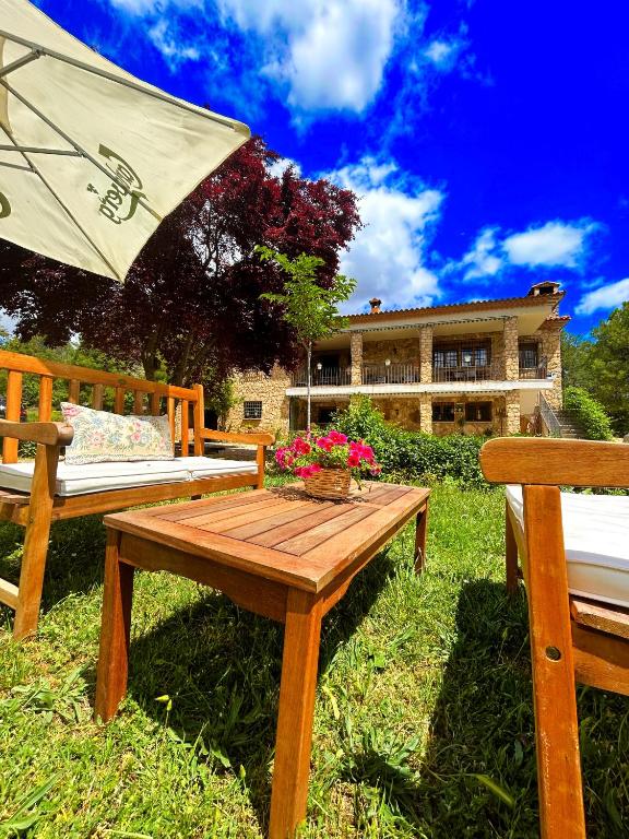 a wooden table with an umbrella and two benches at Villa Sanz in Cuenca