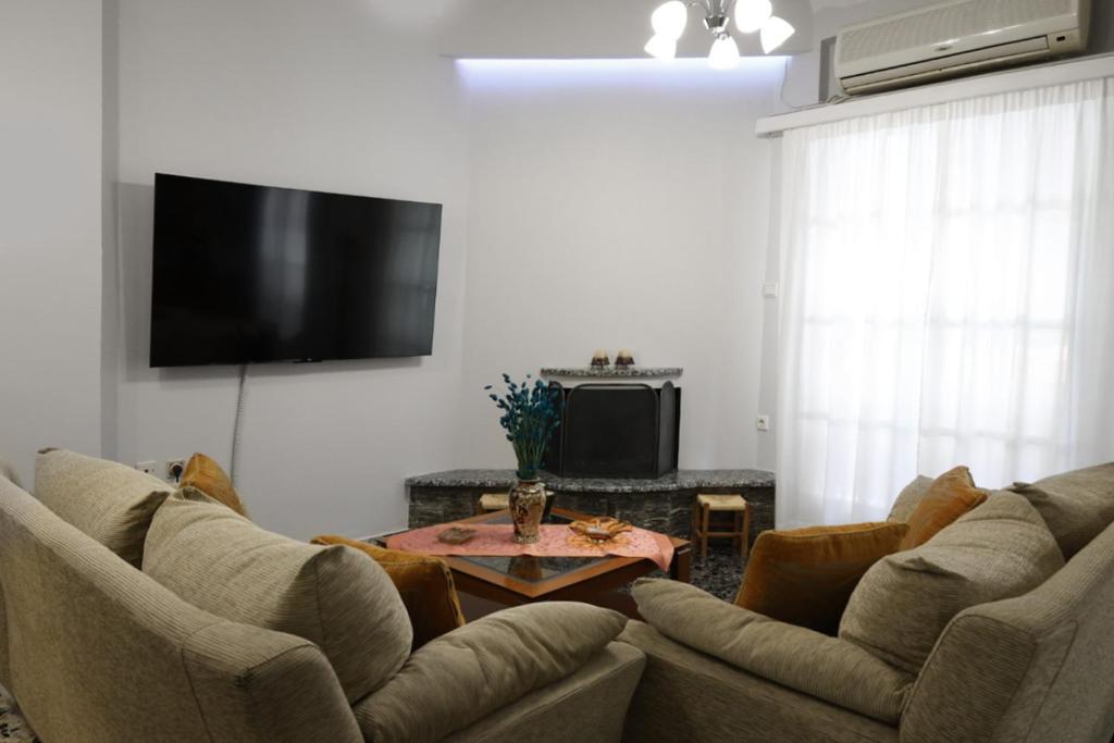 a living room with two couches and a flat screen tv at Efi's apartment in Kalamata