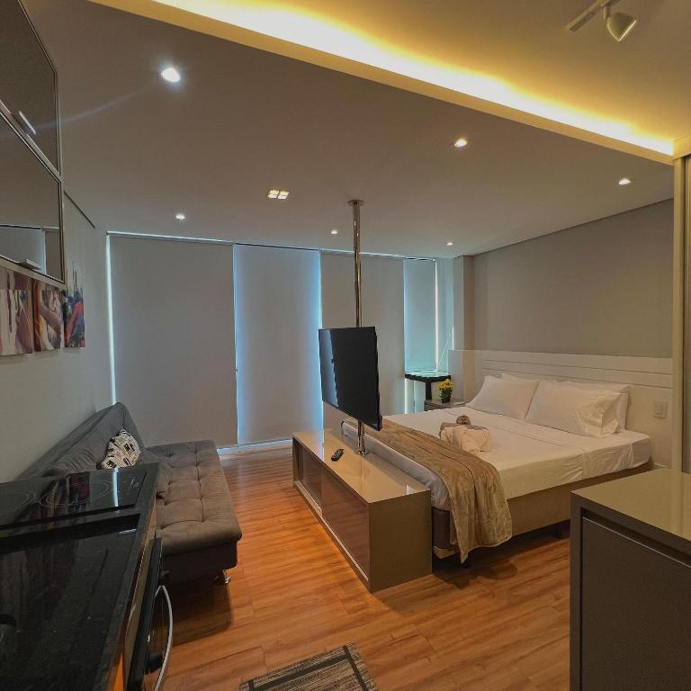 a bedroom with a bed and a tv and a couch at Studio Prime 920 - IS Moema in Sao Paulo