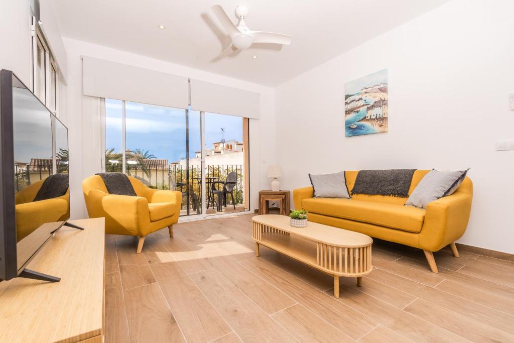 a living room with two yellow couches and a tv at Aparto Almi in Moraira