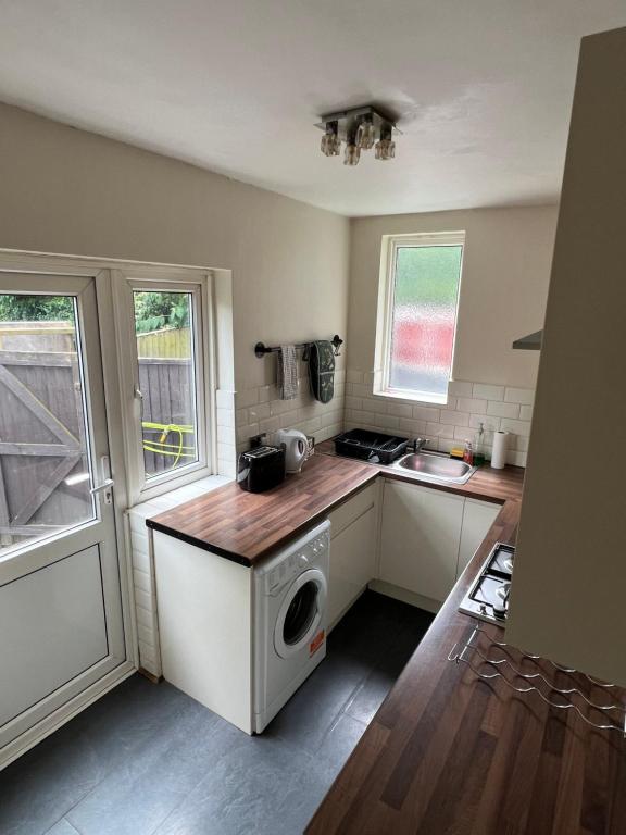 a kitchen with a washer and dryer on a counter at 20mins to BakerSt, Harry Potter & Wembley Stadium! in Northwood