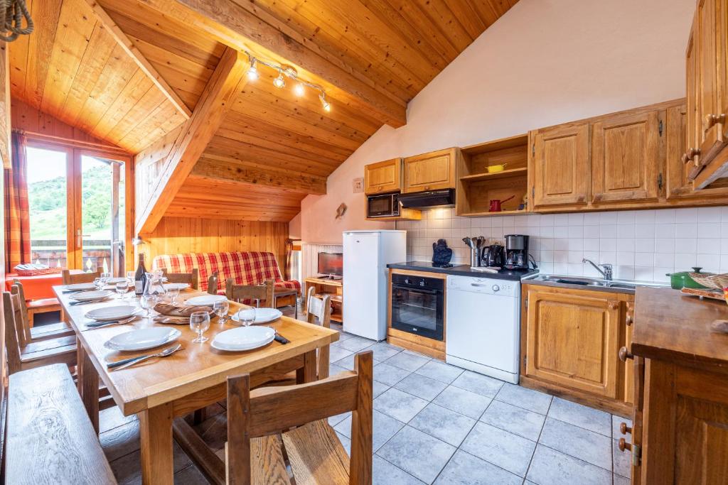 eine Küche mit Tisch und ein Esszimmer in der Unterkunft Chalet Le Choucas N°3 in Levassaix