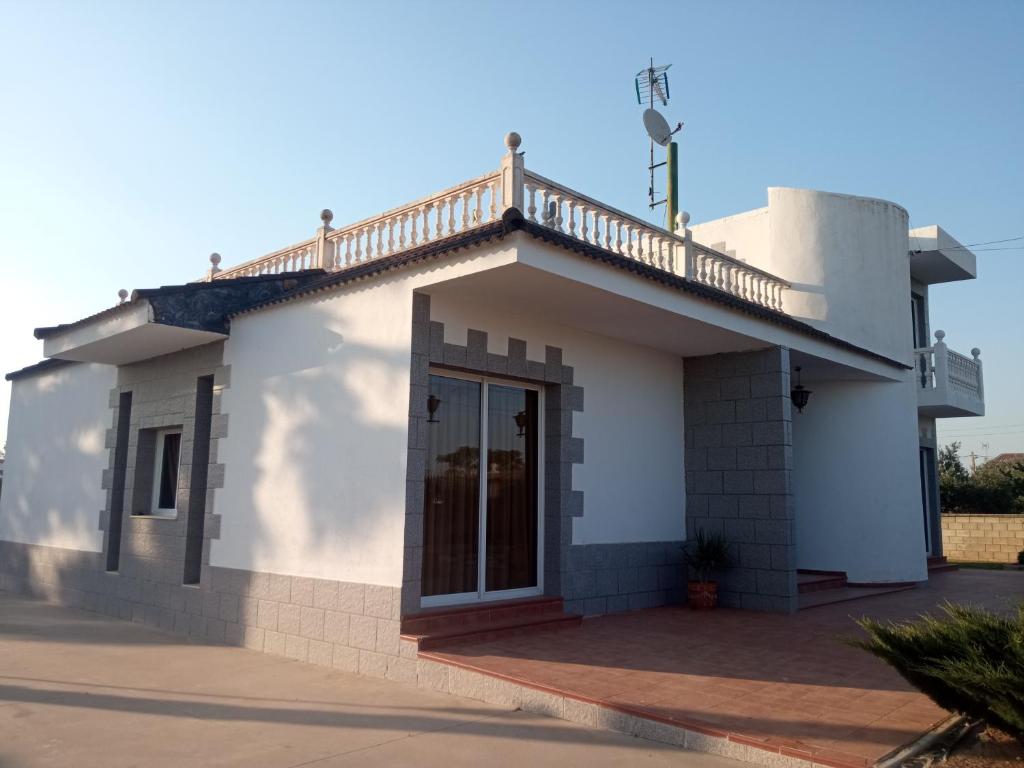 a white house with a balcony on top of it at Villa Santa Ana in La Carlota