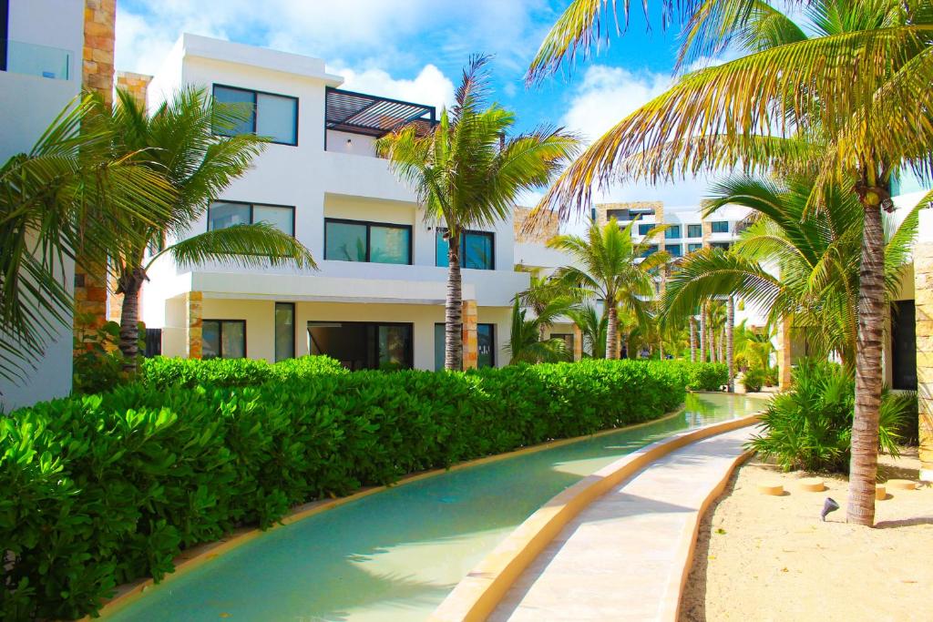 ein Resort mit Palmen und einem Swimmingpool in der Unterkunft Corcomoran Luxury beachfront house in Telchac Puerto