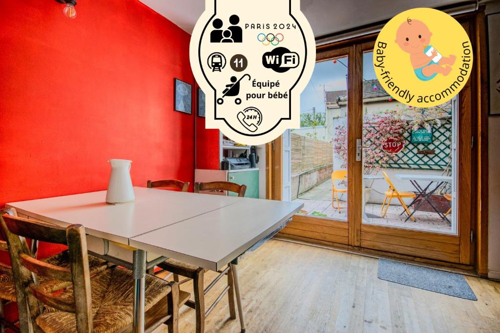 une salle à manger avec une table et un mur rouge dans l'établissement Maison Calme Proche Métro L11, à Montreuil