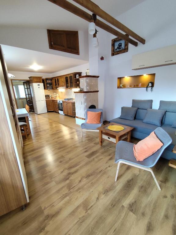 a living room with a blue couch and a kitchen at Apartment My Way in Poprad
