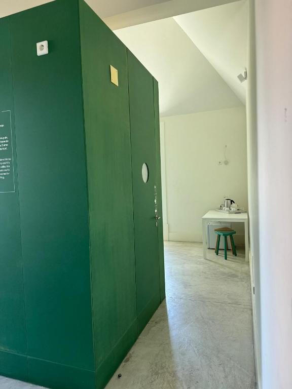 a green wall in a room with a table at Surf & Sea Suites in Parede