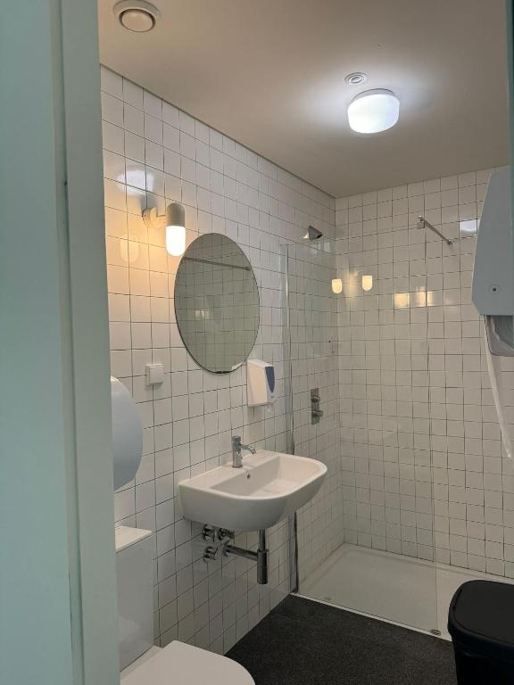 a bathroom with a sink and a toilet and a mirror at Surf & Sea Suites in Parede