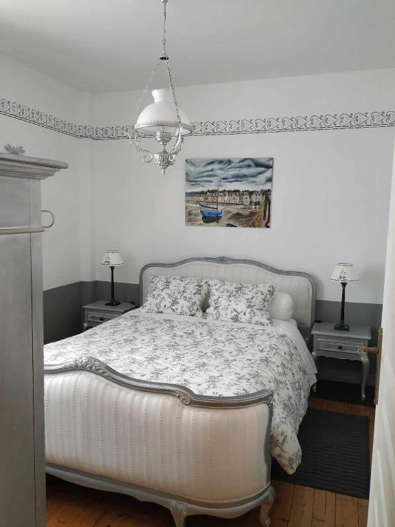 - une chambre avec un lit blanc et deux lampes dans l'établissement Chez Marie, à Cancale