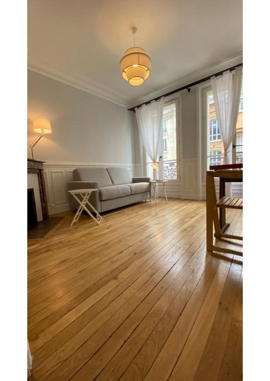 - un salon avec un canapé et du parquet dans l'établissement Sunny Bastille-Roquette Paris, à Paris