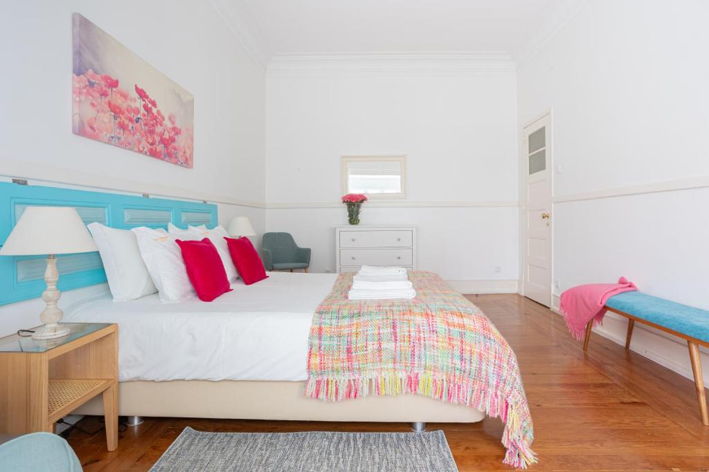 a bedroom with a white bed with red pillows at Casa da Avenida Lisboa in Lisbon