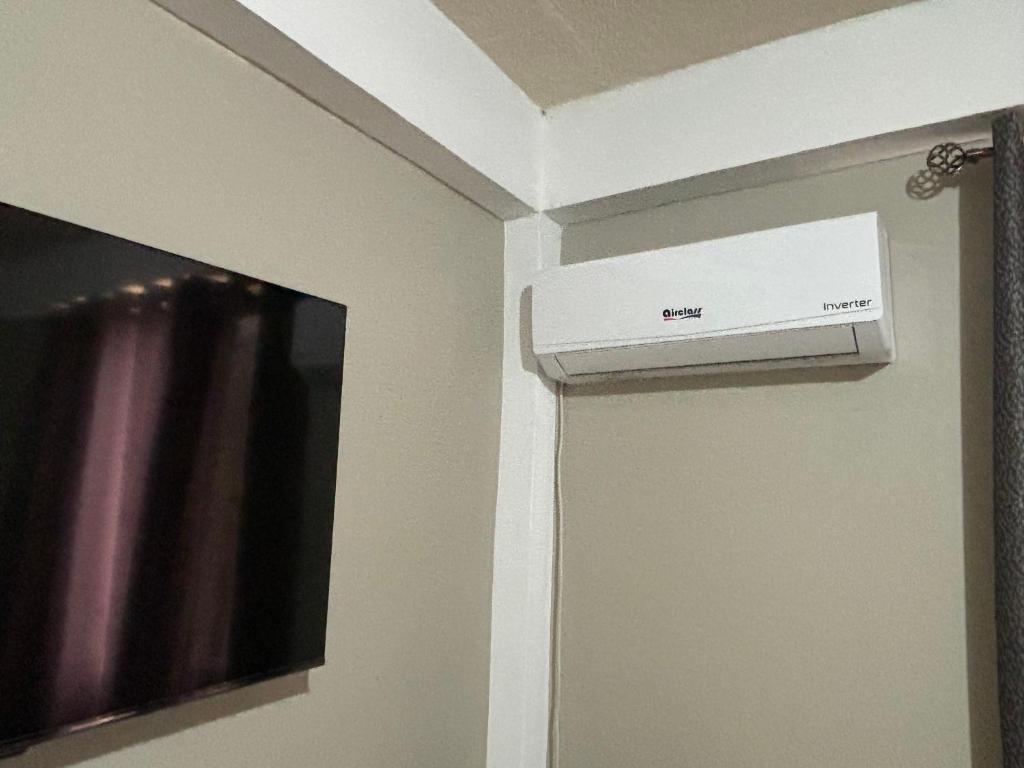 a room with a television and a box on the wall at MJayApartmentRental in Paix Bouche